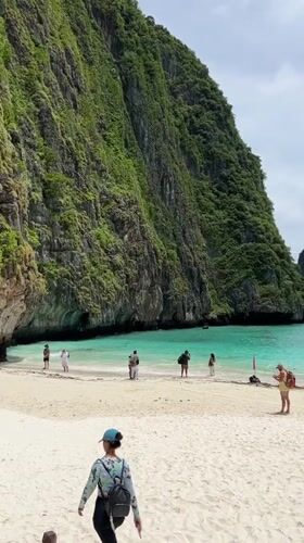 Ao Nang beach scene with crowds, cliffs, and a swim warning