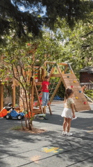Kids at play on a Budva playground, cafe nearby