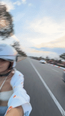 Woman rides scooter through Mui Ne wearing white helmet