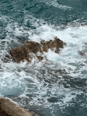 Aerial footage captures waves crashing against Montenegro coastline rocks