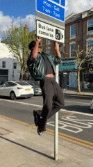Man hangs from bus lane sign in London street