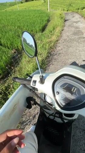 Scooter rider travels through Indonesian rice fields at night