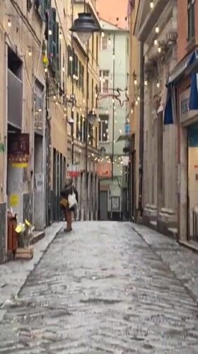 Early morning scene captured on narrow Genoa cobblestone street