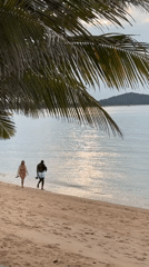Couple enjoys quiet beach walk in Thailand