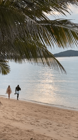 Couple enjoys quiet beach walk in Thailand
