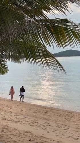 Couple enjoys quiet beach walk in Thailand