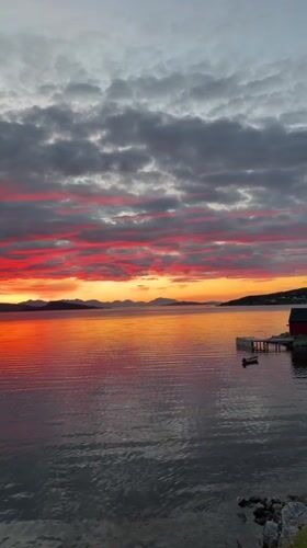 Vivid sunset over calm waters near Harstad, Norway
