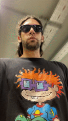 Long-haired man in cartoon shirt walks Buenos Aires tunnel