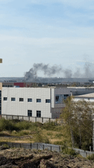 Smoke visible on the Yekaterinburg skyline near a modern building