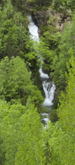 Multi-tier waterfall documented in lush Spanish Pyrenees landscape