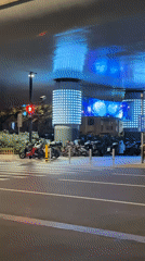Nighttime traffic flows through illuminated Shanghai intersection April 21
