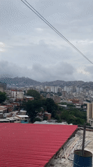 Panoramic views capture Caracas hillside communities under overcast evening sky