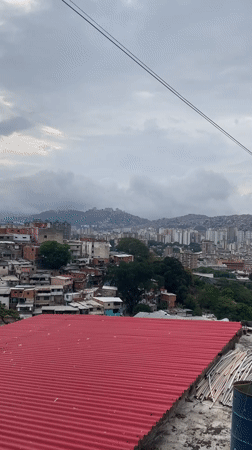 Panoramic views capture Caracas hillside communities under overcast evening sky