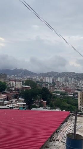 Panoramic views capture Caracas hillside communities under overcast evening sky