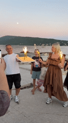Birthday celebration held on pier in Montenegro at twilight