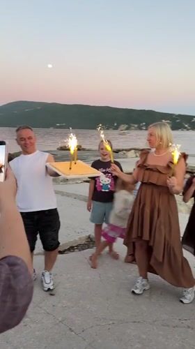 Birthday celebration held on pier in Montenegro at twilight