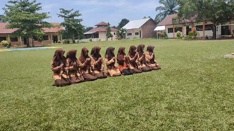 Students perform synchronized dance in uniforms on Indonesian field