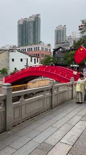 Woman in traditional dress spotted on red bridge in Liwan District