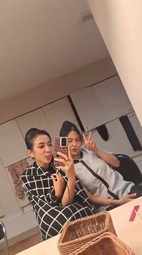 Two women take mirror selfie in Singkawang indoor setting