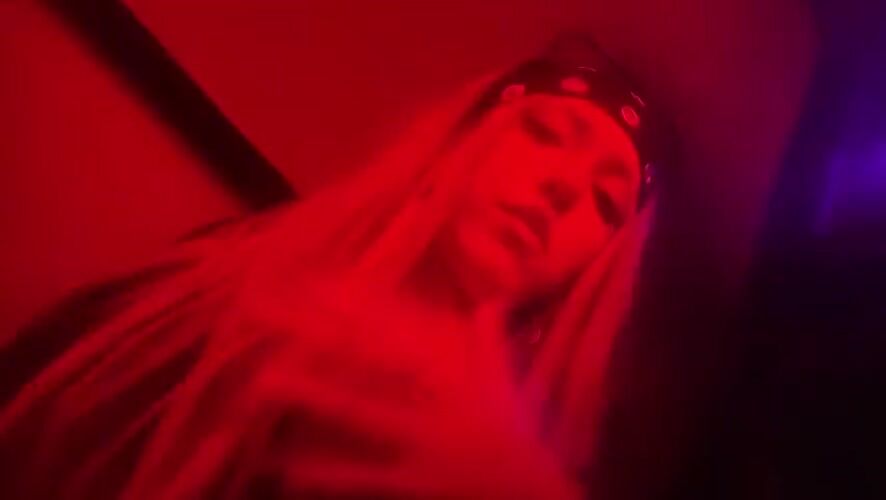 Late-night dancing at a Milan nightclub under red lights