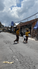 Balinese women carry traditional baskets through Tegallalang streets