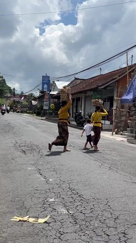 Balinese women carry traditional baskets through Tegallalang streets