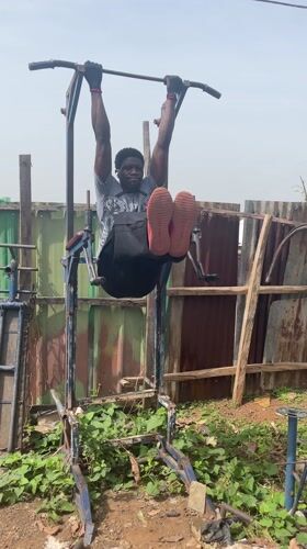 Man exercises on homemade fitness equipment in Akwanga