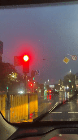 Evening rain creates reflective streets in Minsk traffic