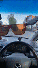 Driver lifts red sunglasses while driving in Irkutsk