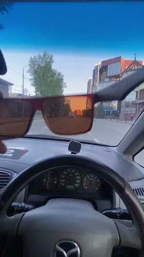 Driver lifts red sunglasses while driving in Irkutsk