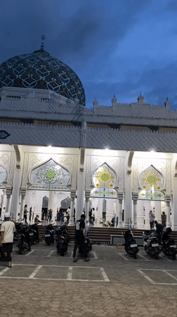 Daily life documented around Lhokseumawe mosque during prayer time