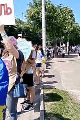 Ukrainian-language demonstration observed on tree-lined sidewalk