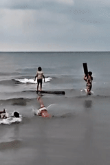 Children play at Indonesian beach during overcast sunset