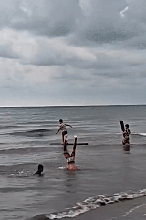 Children play at Indonesian beach during overcast sunset