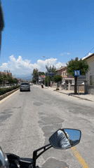 Father and child ride scooter through sunny Fethiye streets