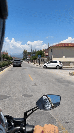 Father and child ride scooter through sunny Fethiye streets