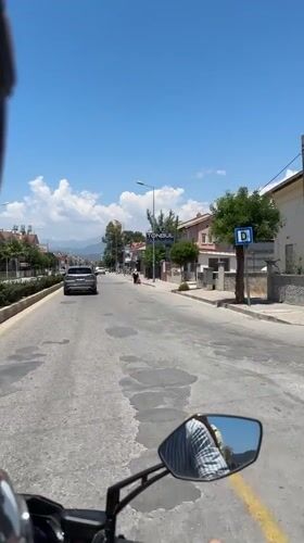 Father and child ride scooter through sunny Fethiye streets