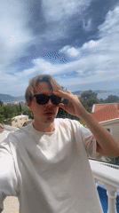Young man poses on balcony in coastal Montenegro