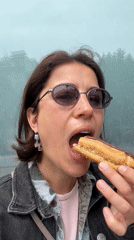 Woman enjoys chocolate éclair near modern Barcelona building