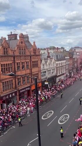 Large red-white clad crowd gathers along London street