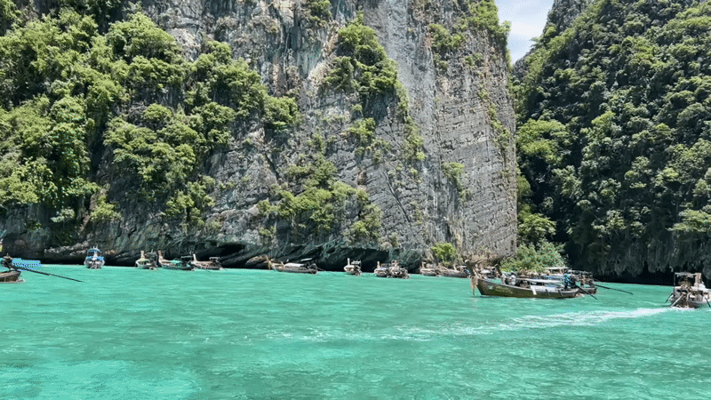 Longtail boats dot turquoise waters between Ao Nang's limestone cliffs