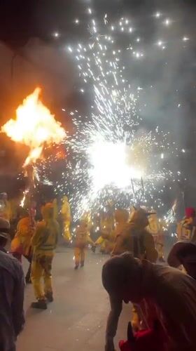Fireworks and crowds in yellow at a Terrassa night event