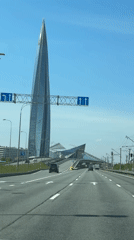 Vehicle travels sunny Saint Petersburg highway past Lakhta Center