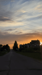 Silver car drives through Прикамский residential area at sunset