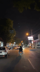 Banner-wearing figure on a Surakarta street at night