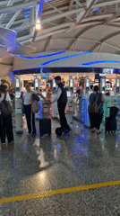 Travelers navigate airport security gates in Kuta, Indonesia