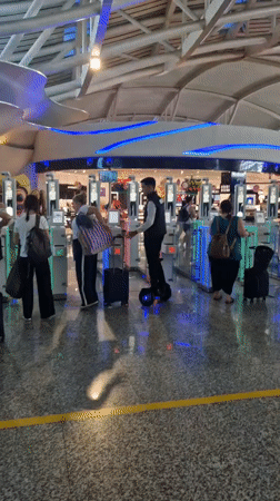 Travelers navigate airport security gates in Kuta, Indonesia