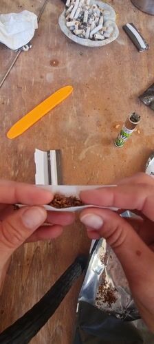 Person rolls cigarette by hand in Lachish region