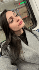 Woman in grey coat rides Moscow train, touches surface