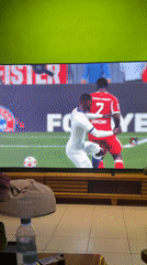 Person plays soccer video game in colorful living room